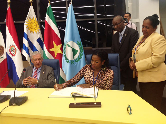 President of Parliament Hon. Gracita Arrindell (seated, 2nd from left) with Sint Maarten MPs Hon. George Pantophlet and MP. Hon. Sylvia Meyers-Olivacce looking on as Arrindell signs the guestbook.