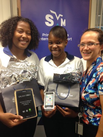 L-R: Jayni Suero and Sue Kishana Bera. both of the St. Maarten Academy pose with their prizes along with Suzy Kartokromo, acting manager, Marketing and Customer Service Department at SXM Airport. (SXM photo) 