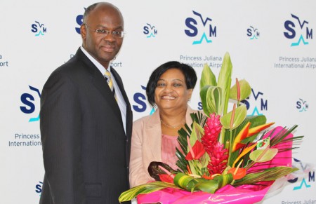 Governor Eugene Holiday poses with his successor at SXM Airport, managing director Regina LaBega after presenting her with a bouquet of flowers on occasion of the airport’s 70th anniversary celebrations. (SXM Airport photo)