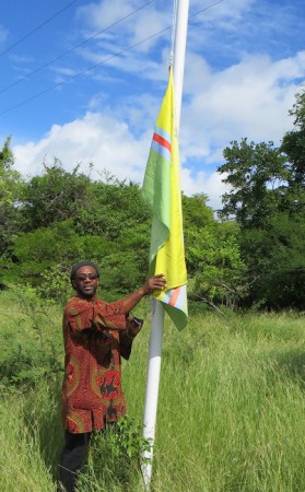 Shujah Reiph with the Unity Flag of St. Martin at half-mast on Friday. (CLF photo