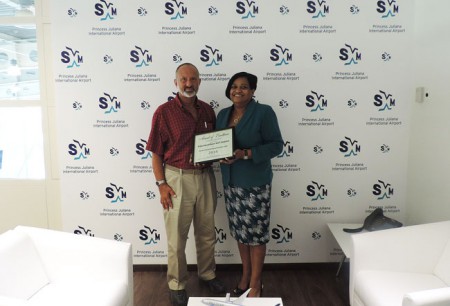 Jeff Berger (L), CEO of JMB Communications, presents the Award of Excellence for SXM to Regina LaBega, Managing Director of SXM Airport in her office last week. (SXM photo)