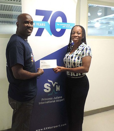 Pictured is Jerome Gumbs, SXM Business Development Analyst, handing over the check to Dr. Rhoda Arrindell of UA. (SXM photo)