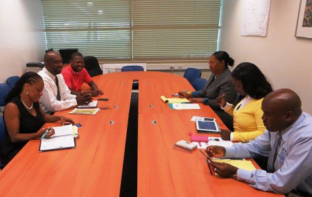 Representatives of the SXM Airport Marketing & Customer Service Department, table right (R-L): Jerome Gumbs, Audrey Jack, and Daphne Nicholson, meeting with St. Martin Book Fair Committee members, table left (L-R), Dr. Rhoda Arrindell, Shujah Reiph, Conneir Thelwell. 
