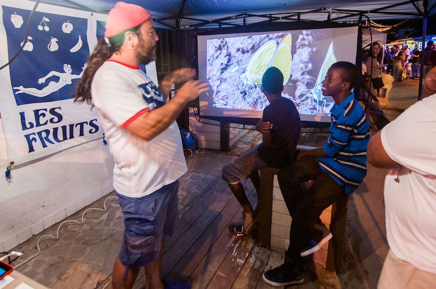 Les Fruits de Mer talk to local youth about the explosion of butterflies on the island at their Mardis de Grand Case booth. (Photo by Jennifer Yerkes.)